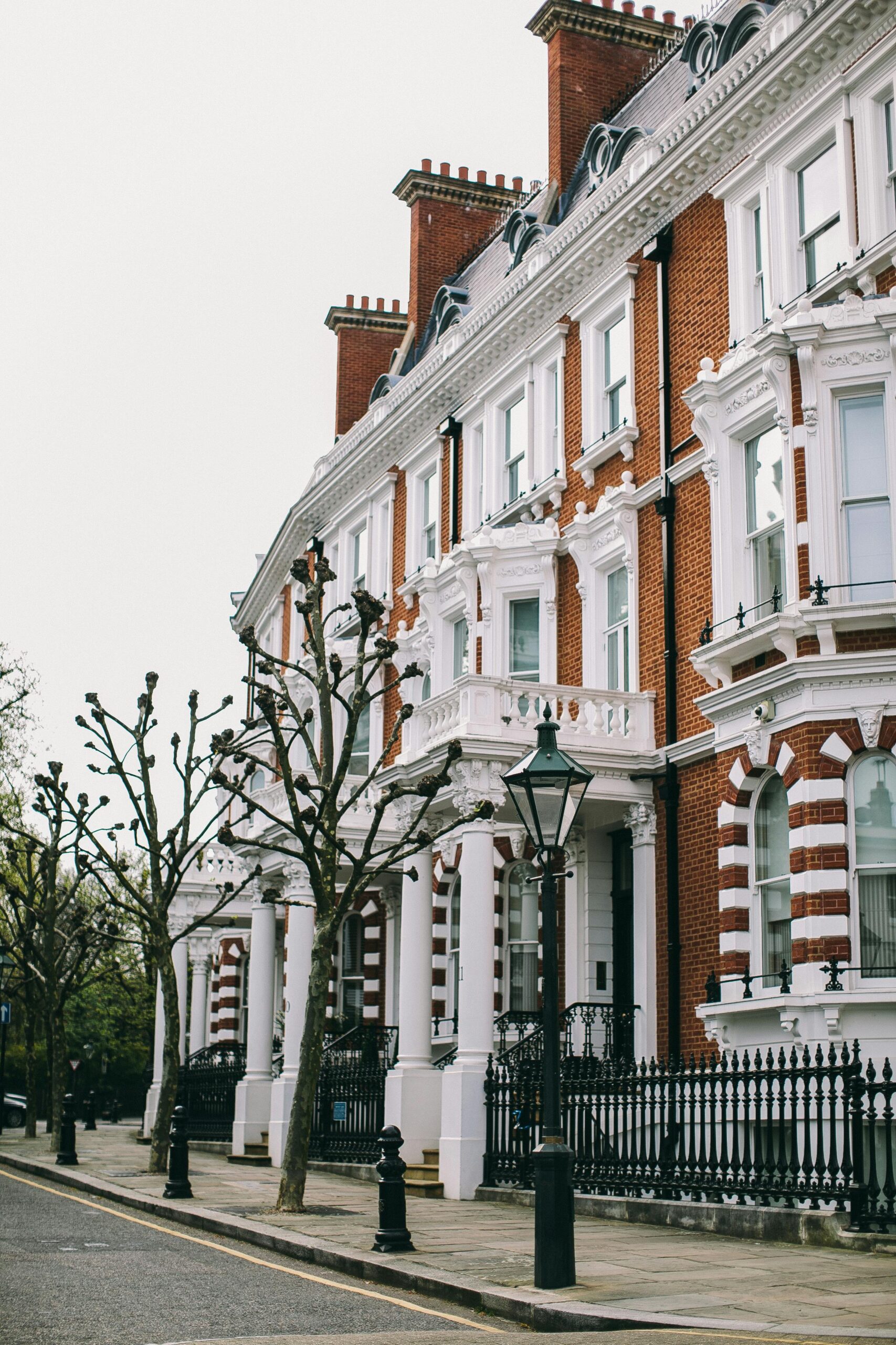 Victorian terraced houses with detailed facades on a quiet London street, exuding classic elegance.